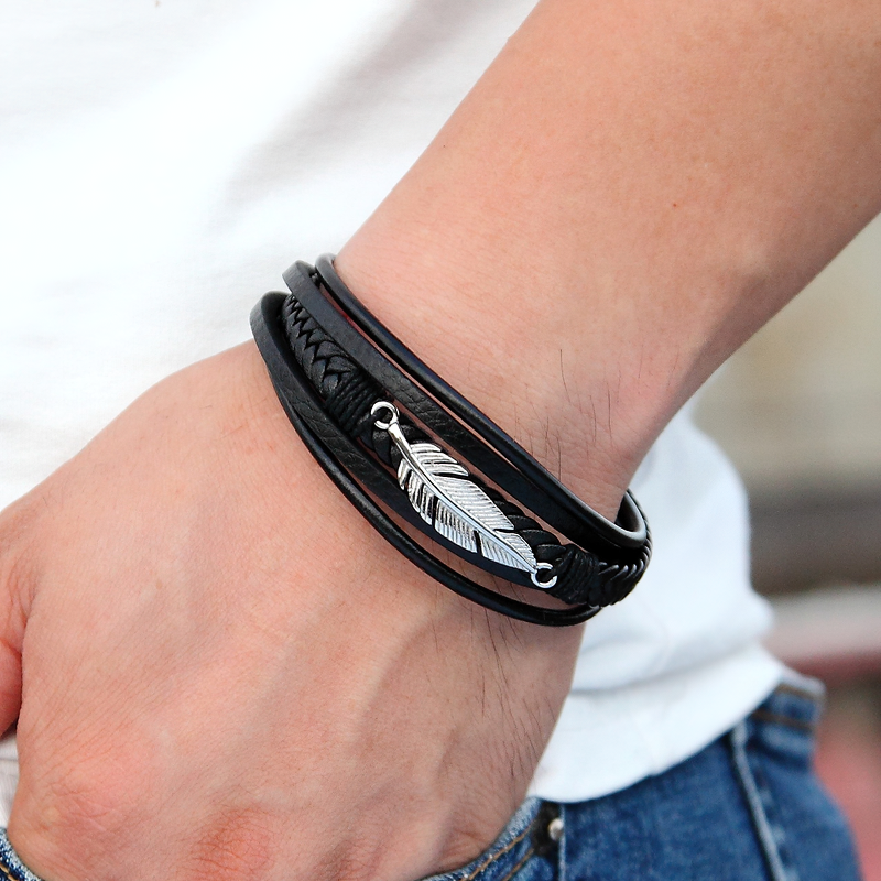 Stylish black genuine leather bracelet for men and women, featuring a trendy stainless steel feather charm.