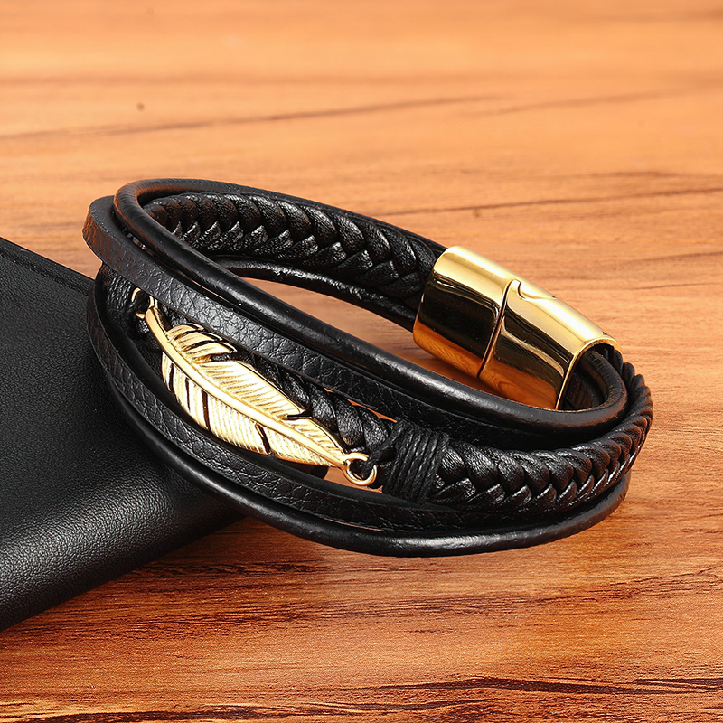 Trendy black leather bracelet with gold stainless steel feather detail, perfect accessory for men and women.