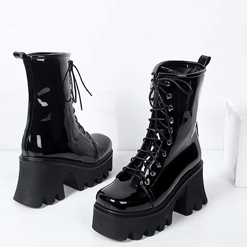 Stylish women's black genuine leather platform boots with a round toe and lace-up design.