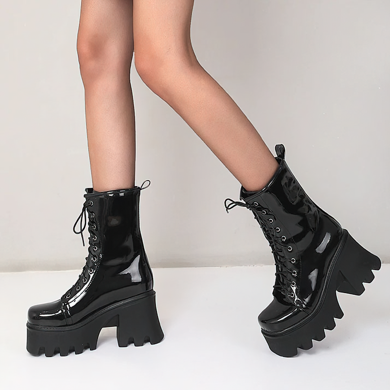 Stylish women's black patent leather platform ankle boots with lace-up design and chunky tractor sole.