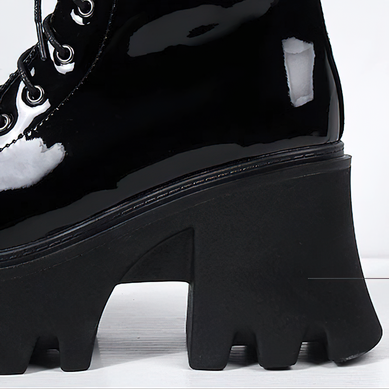 Close-up of women's black genuine leather platform boots with a chunky tractor sole and lace-up detail.