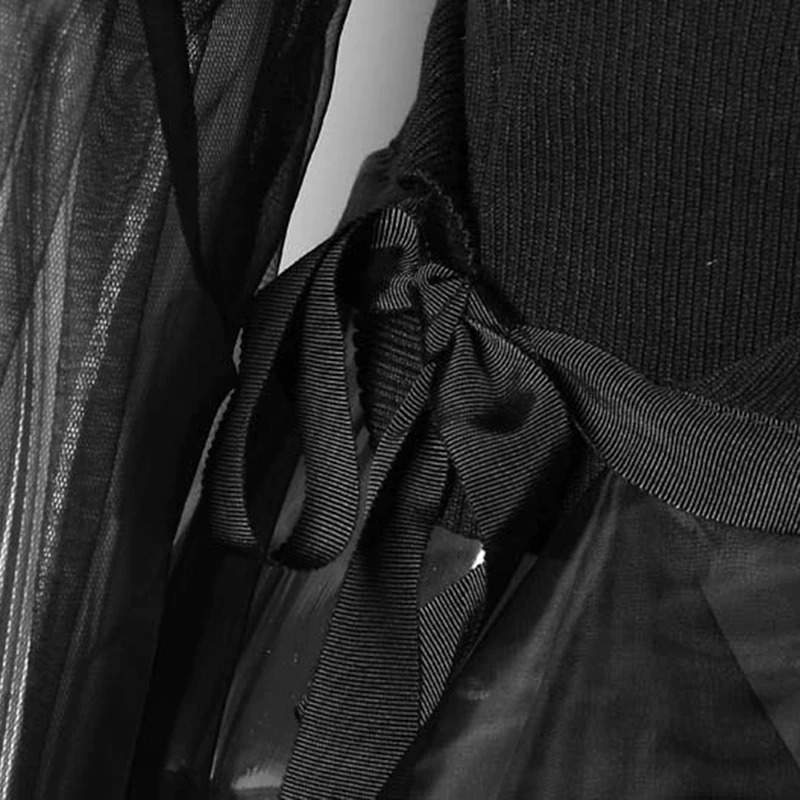 Close-up of a black gothic dress with sheer fabric and ribbon detailing, showcasing alternative fashion style.