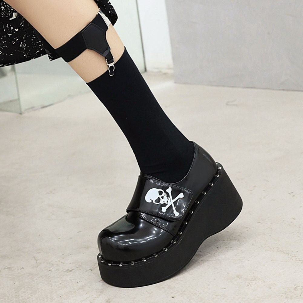 Gothic platform shoes for women with skull design, featuring velcro straps and stylish black patent leather.