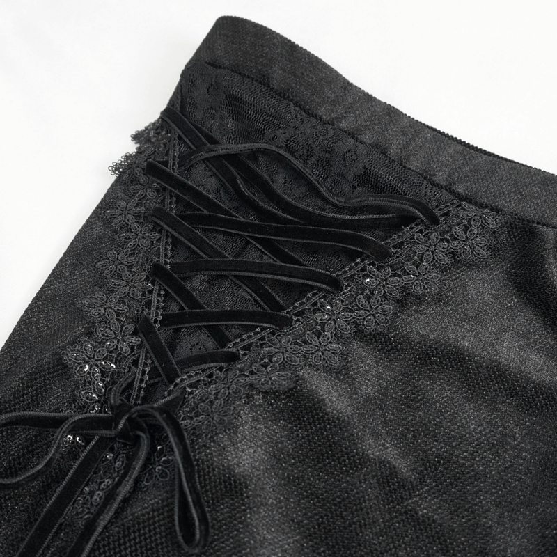 Close-up of gothic velvet flare pants featuring lace-up accents and floral details on the side.