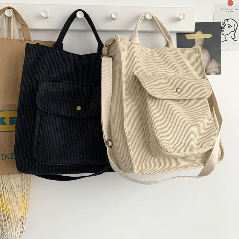 Two stylish corduroy handbags hanging, one black and one beige, showcasing casual elegance for everyday use.