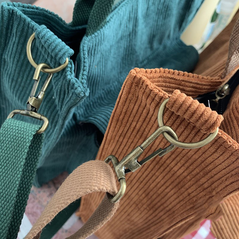 Close-up of ladies corduroy handbags in teal and rust, showcasing quality fabric and stylish design for casual outings.
