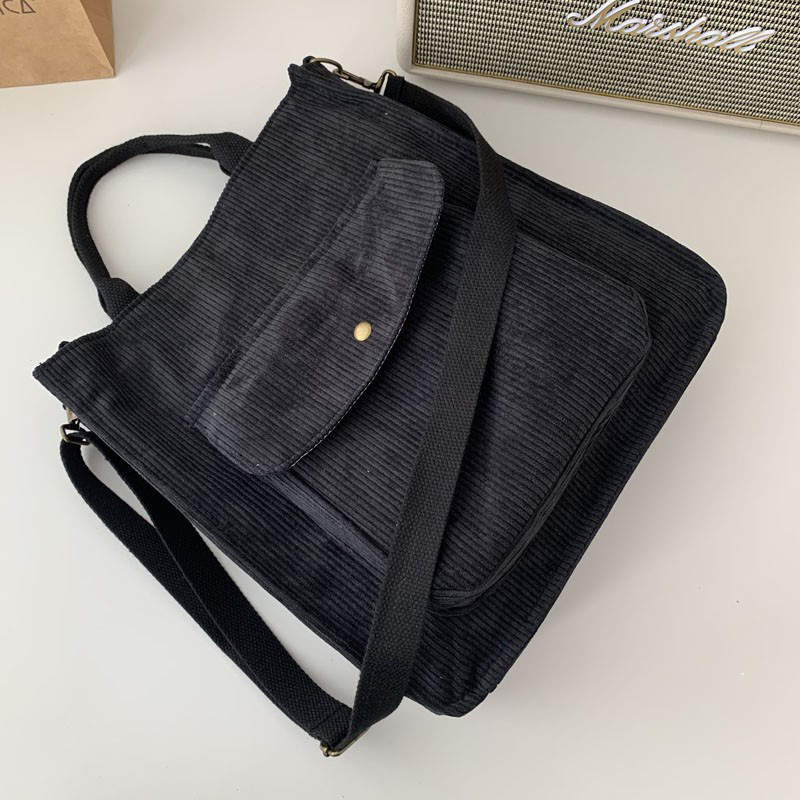 Casual ladies corduroy handbag in black, featuring a front pocket and adjustable strap, perfect for daily use.