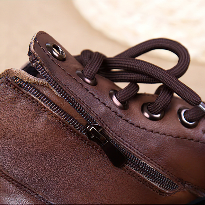 Close-up of stylish women's brown leather ankle boots with zipper and lace details, perfect for casual outfits.