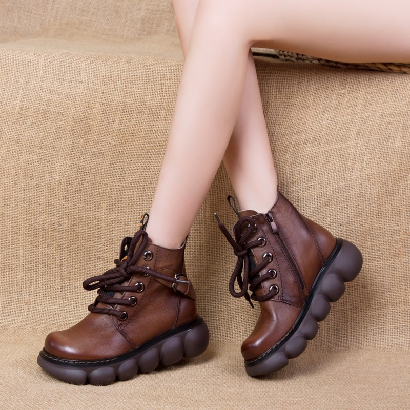 Fashionable women's brown leather ankle boots with thick platforms and laces, perfect for casual wear.