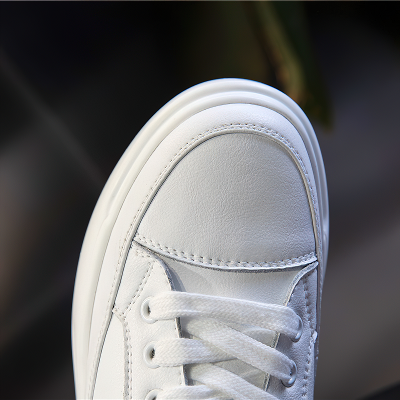 Close-up of stylish white lace-up genuine leather sneaker showcasing soft texture and sleek design.