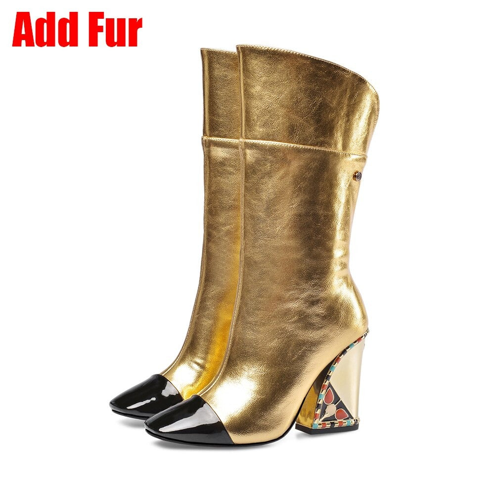 Stylish gold mid-calf boots with black patent toe and embroidered heel, perfect for a fashionable statement.