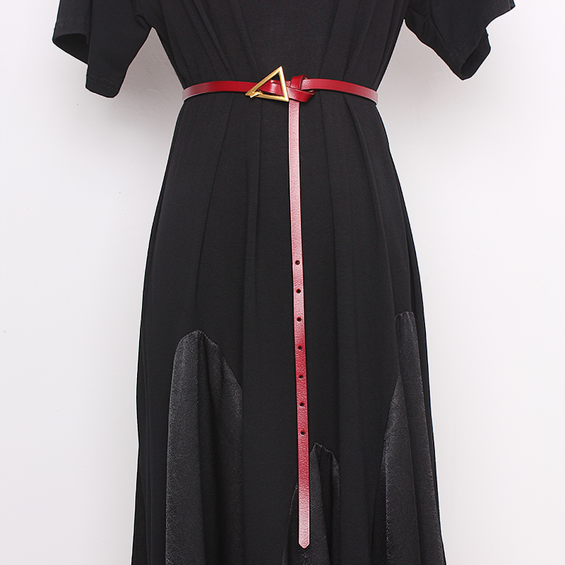 Elegant red PU leather belt with metal triangle buckle accentuating a stylish black dress.