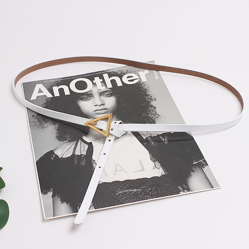 Elegant PU leather belt with a metal triangle buckle, styled on a magazine for a trendy fashion look.