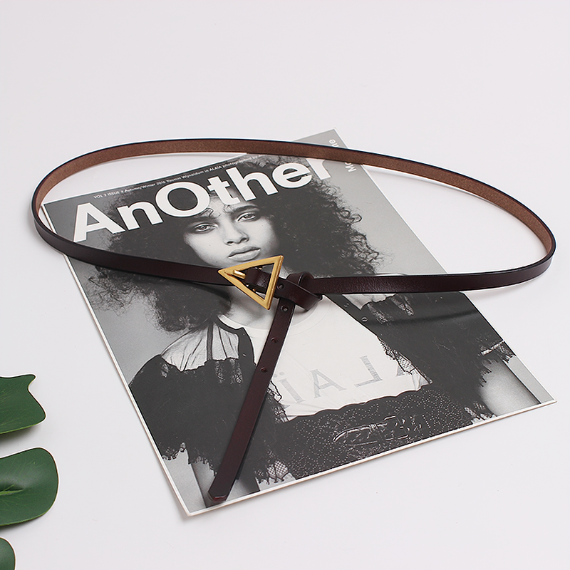 Elegant PU leather belt with a metal triangle buckle, styled on a fashion magazine for trendy outfit inspiration.