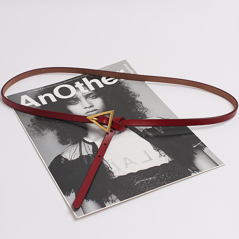 Elegant PU leather belt with metal triangle buckle, styled with fashion magazine backdrop.
