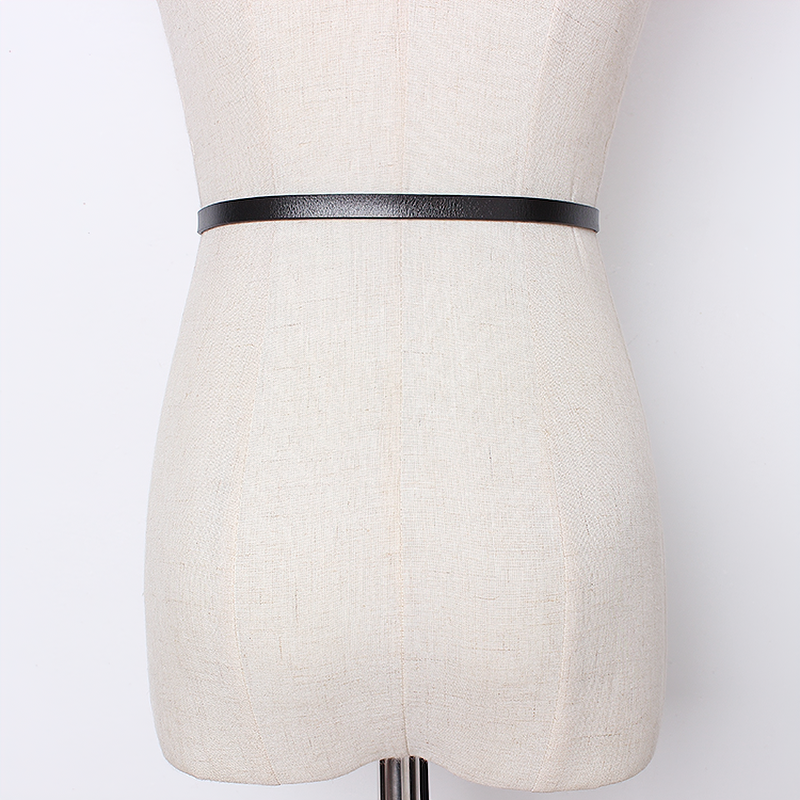 Slim black PU leather belt on a dress form showcasing trendy metal triangle buckle design.