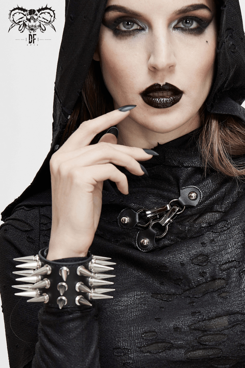 Unisex fashion model wearing a stylish punk black outfit with a spiked PU leather bracelet and dramatic makeup.