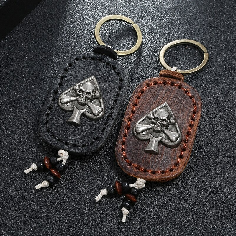 Gothic leather skull keychain set in black and brown with silver spade pendant, perfect for car keys or bag accessories.