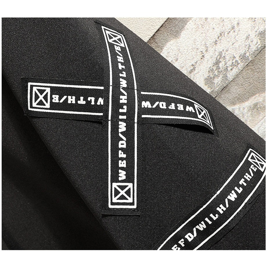 Close-up of creative printed patches on a black men's casual coat showcasing alternative fashion details.