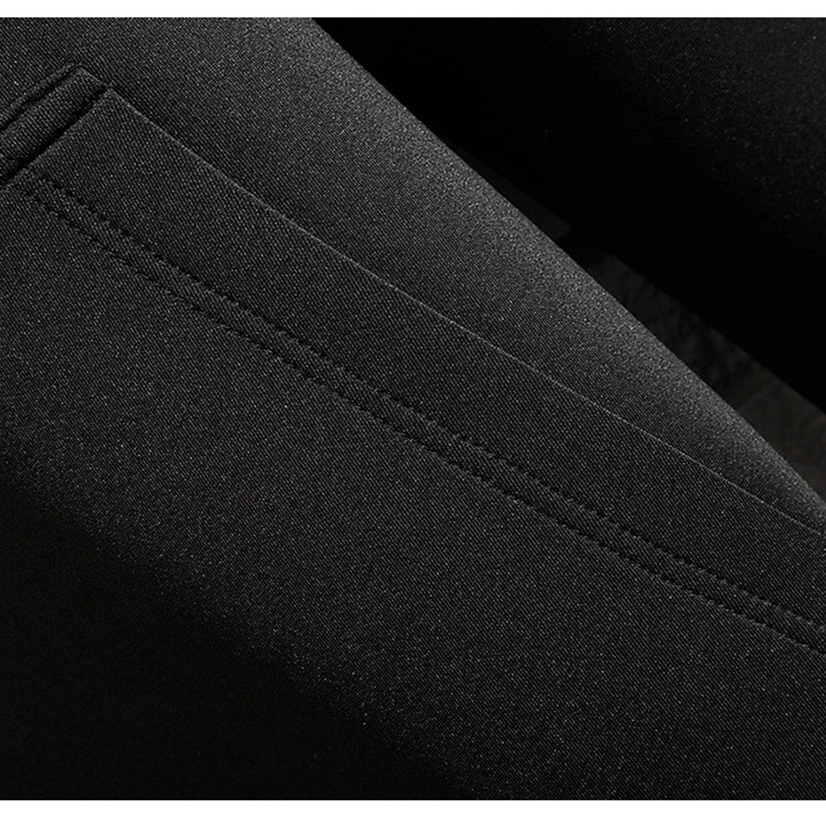 Close-up of the sleek black fabric and stitching detail of a men's casual long coat.