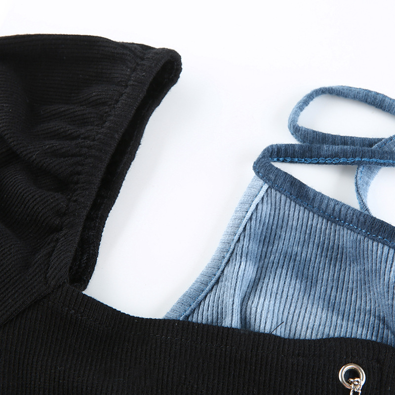 Close-up of gothic women's black crop top with patchwork blue straps and stylish silver chain detail.