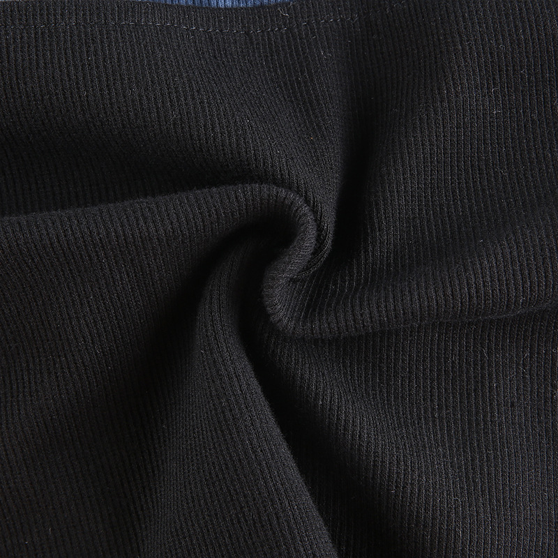Close-up of soft black ribbed fabric for a gothic women's crop top, showcasing texture and flexibility.