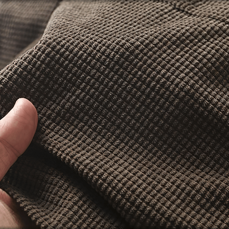Close-up of textured brown fabric showcasing the soft material of an oversized men's shirt with big pockets.