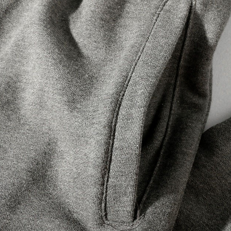 Close-up of the side pocket detail on grey casual men’s pants with an elastic waist and comfortable fabric.