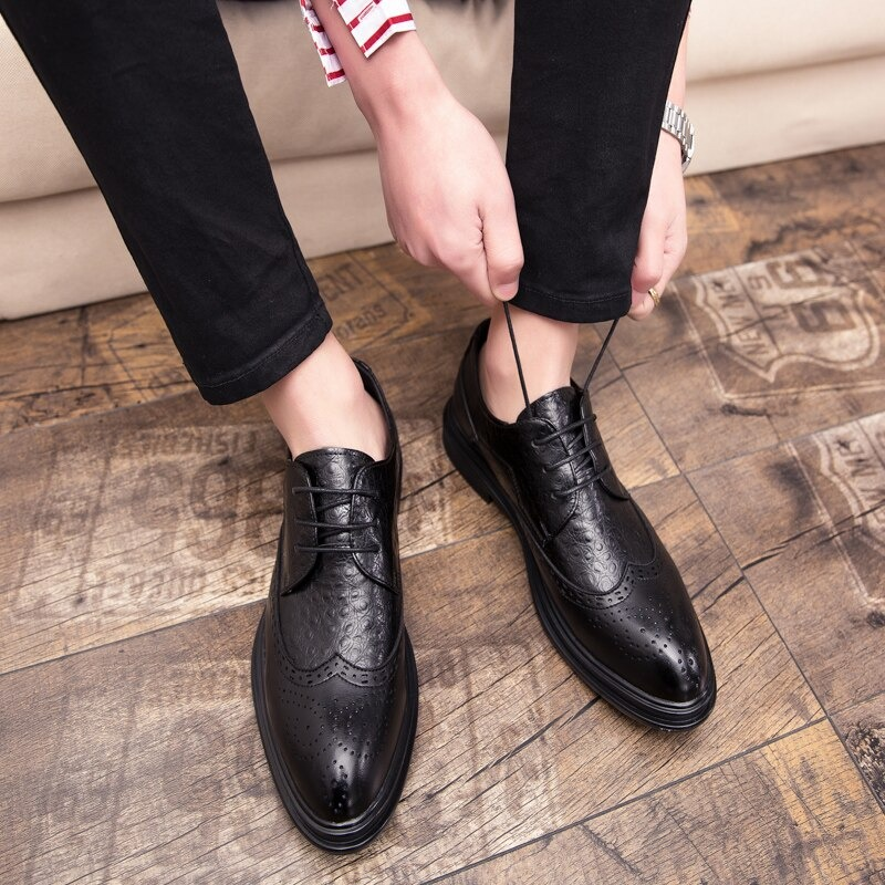 Man lacing up stylish black genuine leather derby shoes for a trendy casual look.