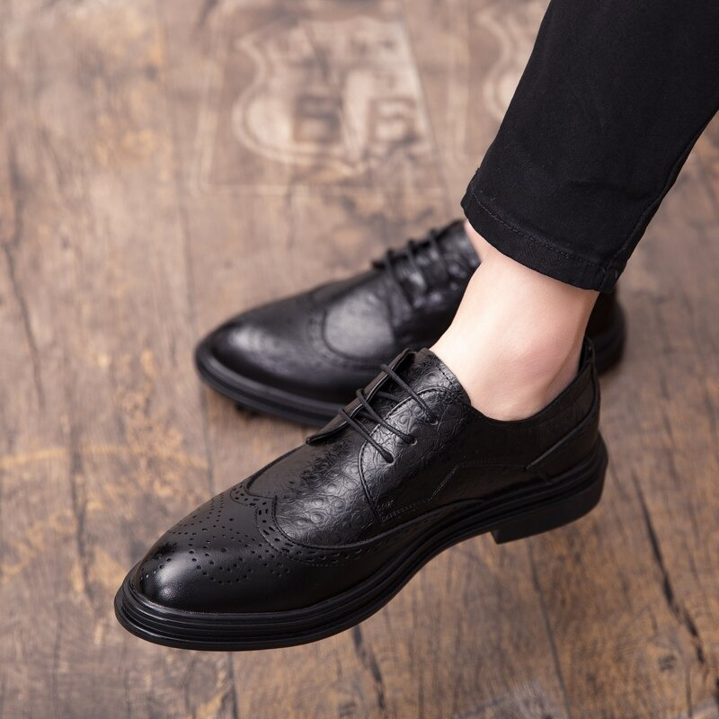 Stylish black genuine leather derby shoes on a wooden floor, perfect for casual looks and modern fashion.