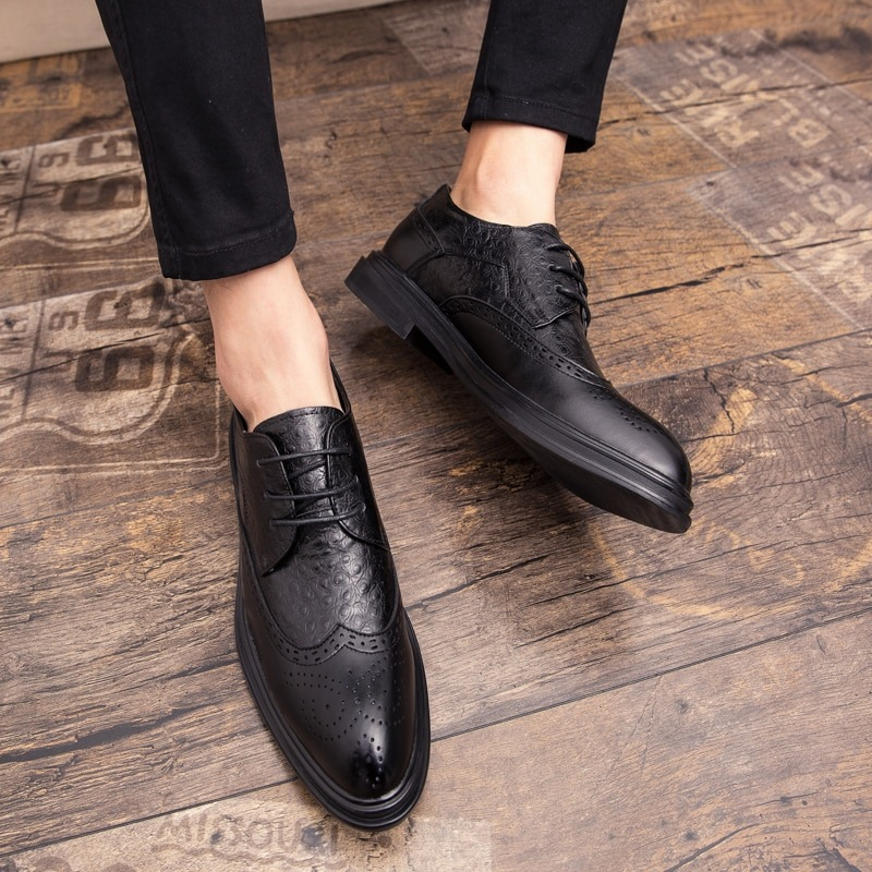 Stylish black genuine leather derby shoes on a wooden floor, perfect for casual fashion.