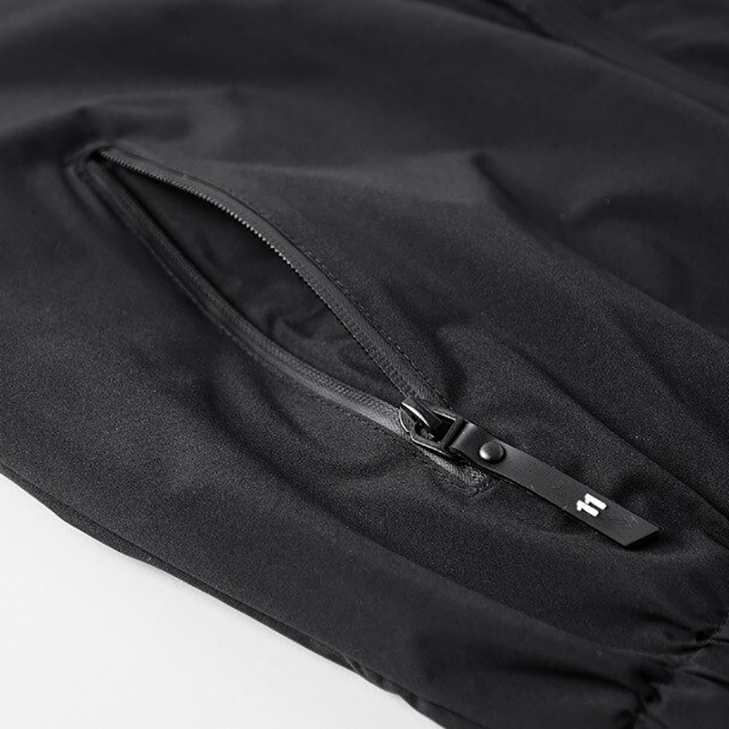 Close-up of the zipper detail on a sleek black male zip-up jacket, showcasing a stylish and functional design.