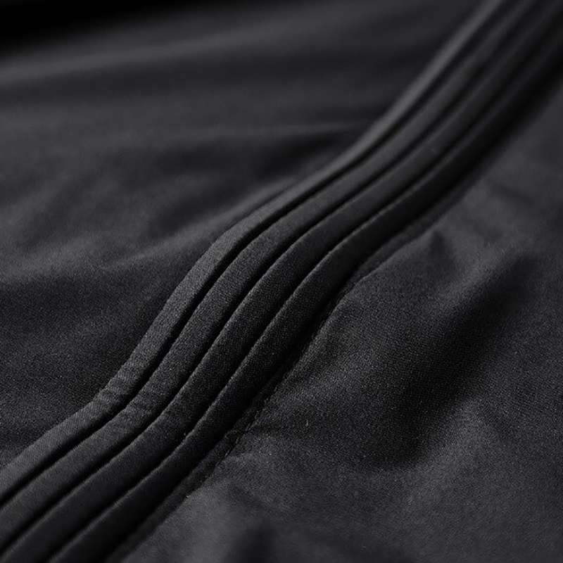 Close-up of black fabric detailing on a men's zip-up jacket, showcasing a soft and sleek texture.