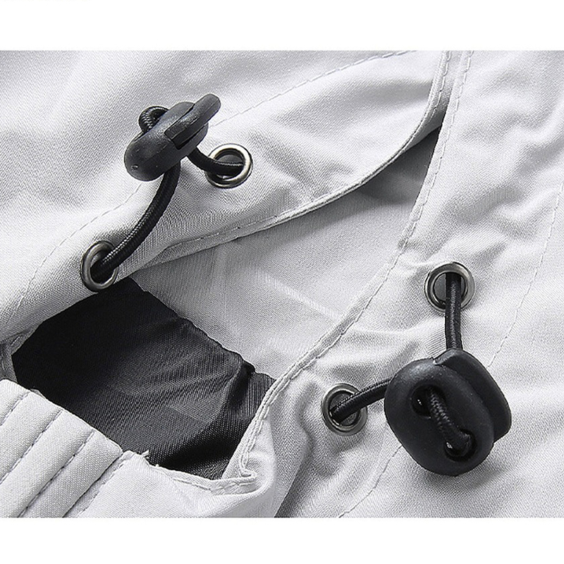 Close-up of the adjustable drawstrings and grommets on a stylish male zip-up jacket, showcasing its functional design.