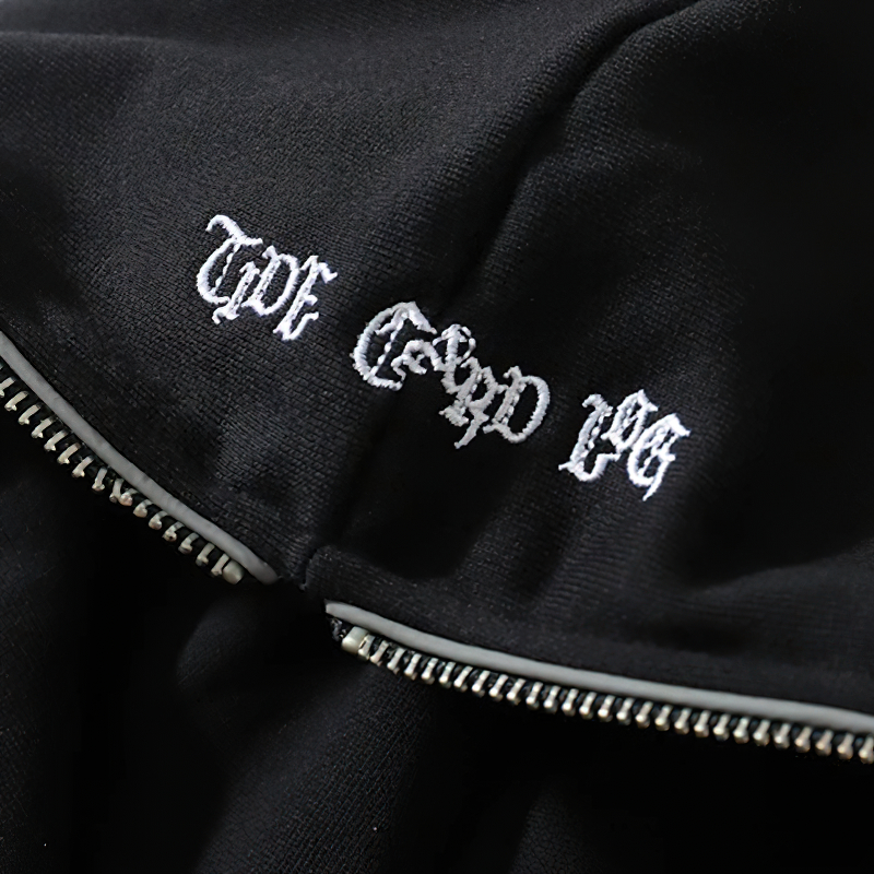 Close-up of black zipper hoodie with punk graphic print and stylish logo embroidery.