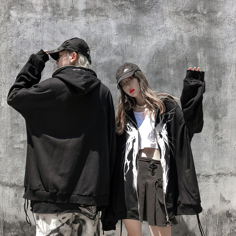 Trendy oversized black hoodies with graphic prints, styled by two fashion-forward individuals outdoors.