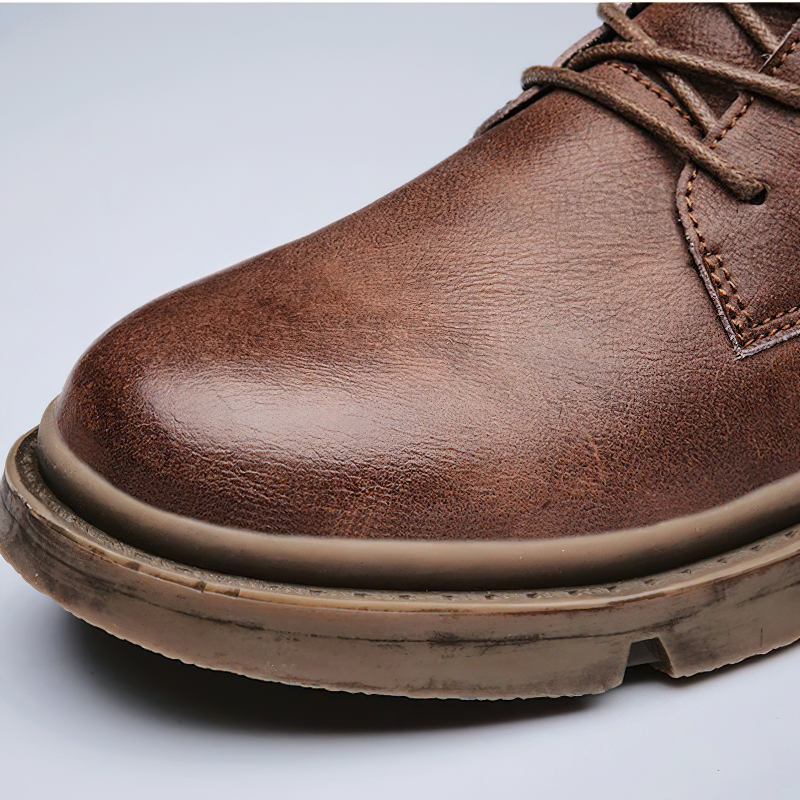 Close-up of brown men's ankle leather boot showing quality texture and casual design for stylish British outfits.