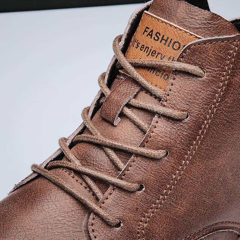 Close-up of stylish men's ankle leather boots in brown with laces and quality texture, ideal for casual wear.