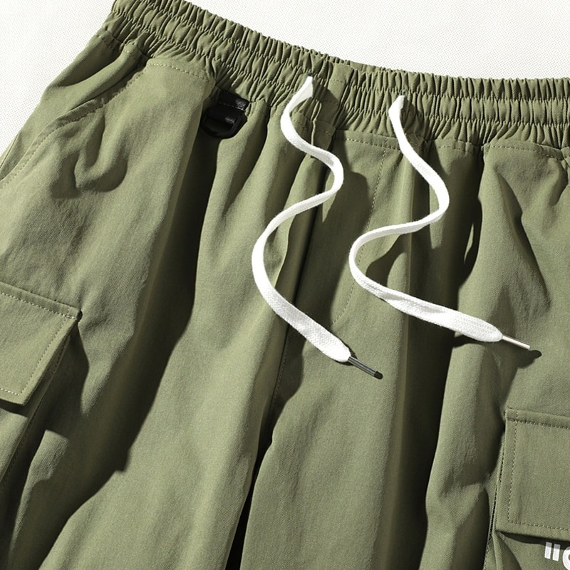 Men's elastic waist shorts in olive green with multi pockets and drawstring detail for casual style.