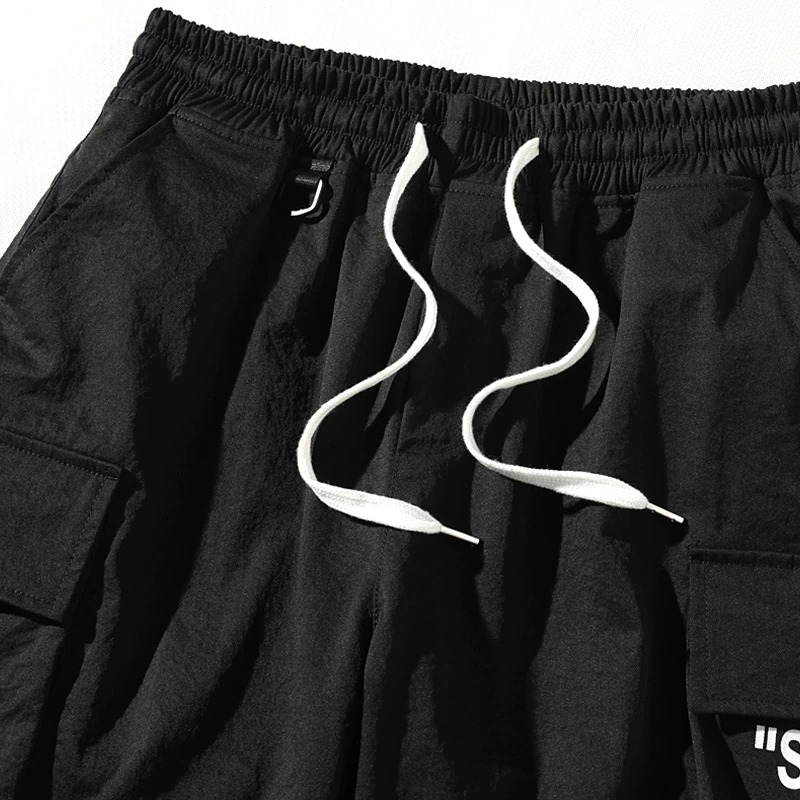 Men's black elastic waist shorts featuring stylish drawstrings and multi-pocket design for casual wear.