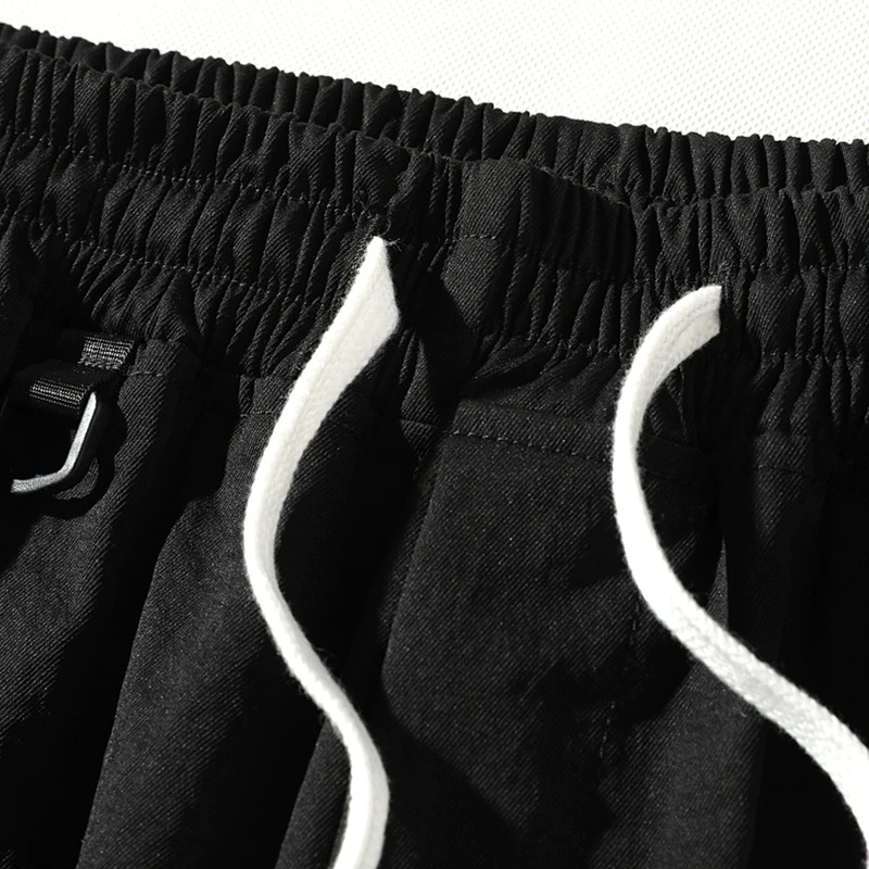 Close-up of black men's elastic waist shorts with drawstring detail, showcasing stylish and comfortable casual wear.