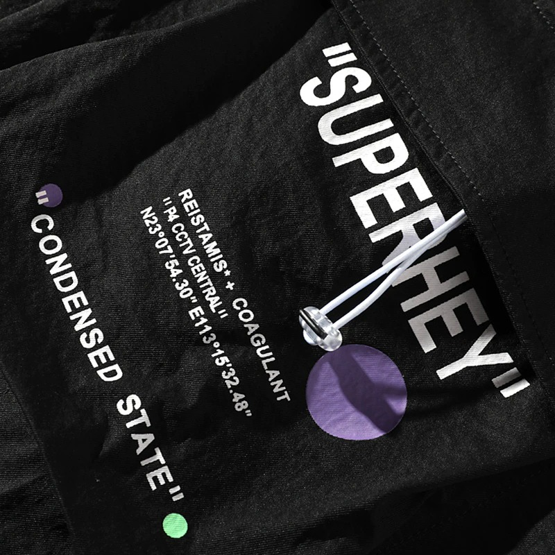 Close-up of black fabric with text "SUPERHEY" and graphics, showcasing trendy streetwear design.