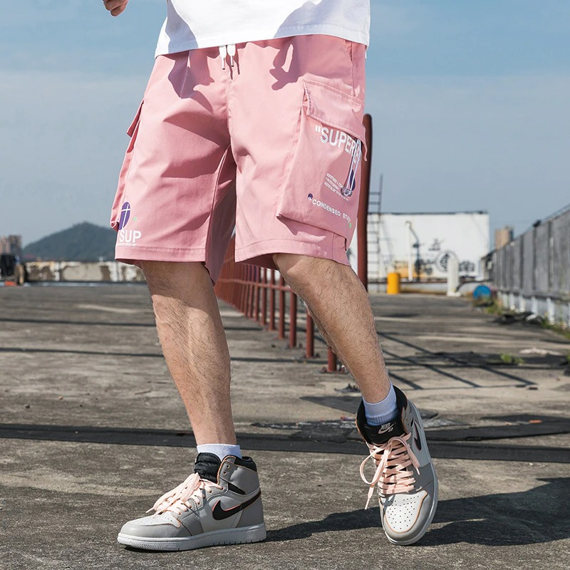 Stylish men's pink elastic waist shorts with multi-pocket design, perfect for casual outings and everyday wear.