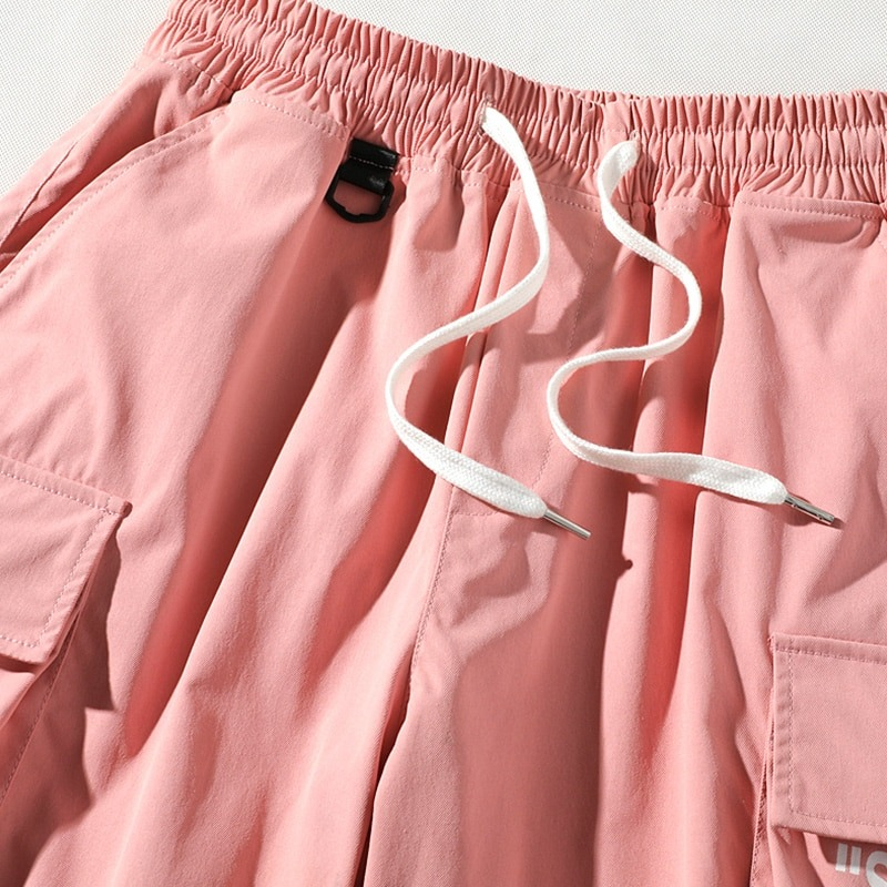 Stylish men's elastic waist shorts in pink with drawstrings and multi-pockets for casual summer wear.