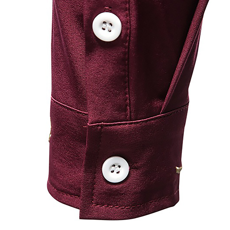 Close-up of a burgundy men's shirt cuff with white buttons, showcasing quality fabric in an asymmetric design.