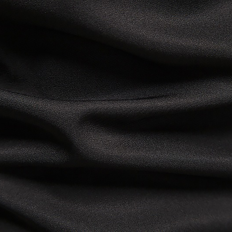 Close-up of black cotton fabric showcasing its smooth, breathable texture suitable for fashion shirts.