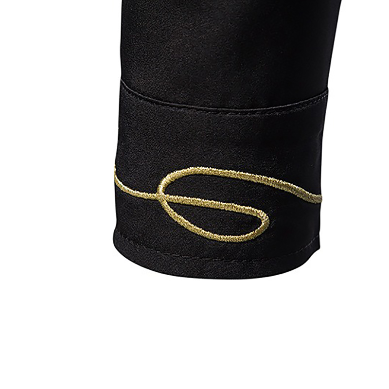 Close-up of the cuff of a black men's shirt featuring elegant gold embroidery design.