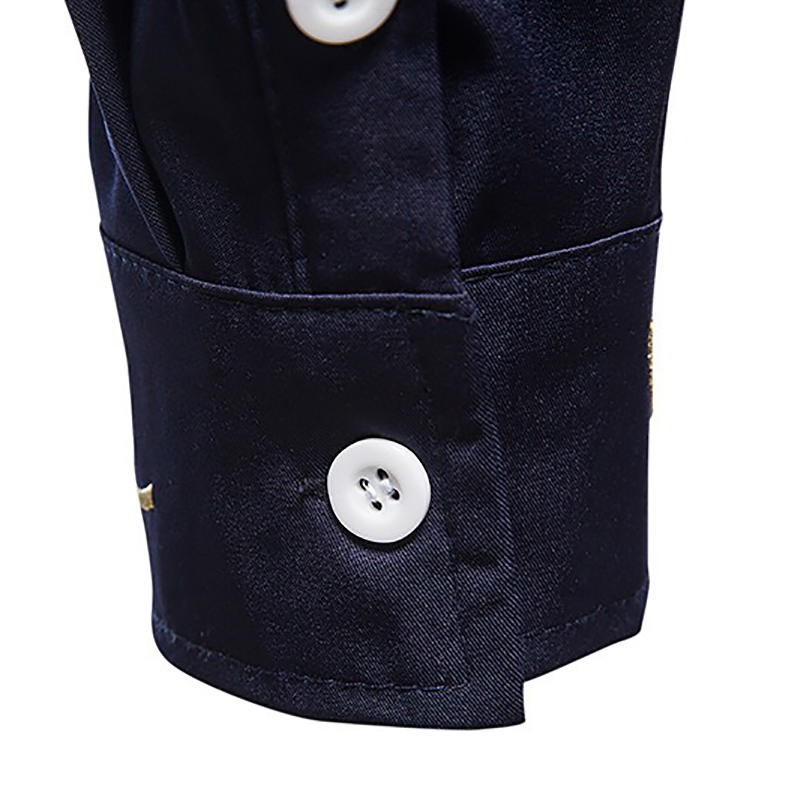 Close-up of the cuff of a men's embroidered asymmetric long-sleeved shirt, featuring white buttons and a sleek cotton fabric.