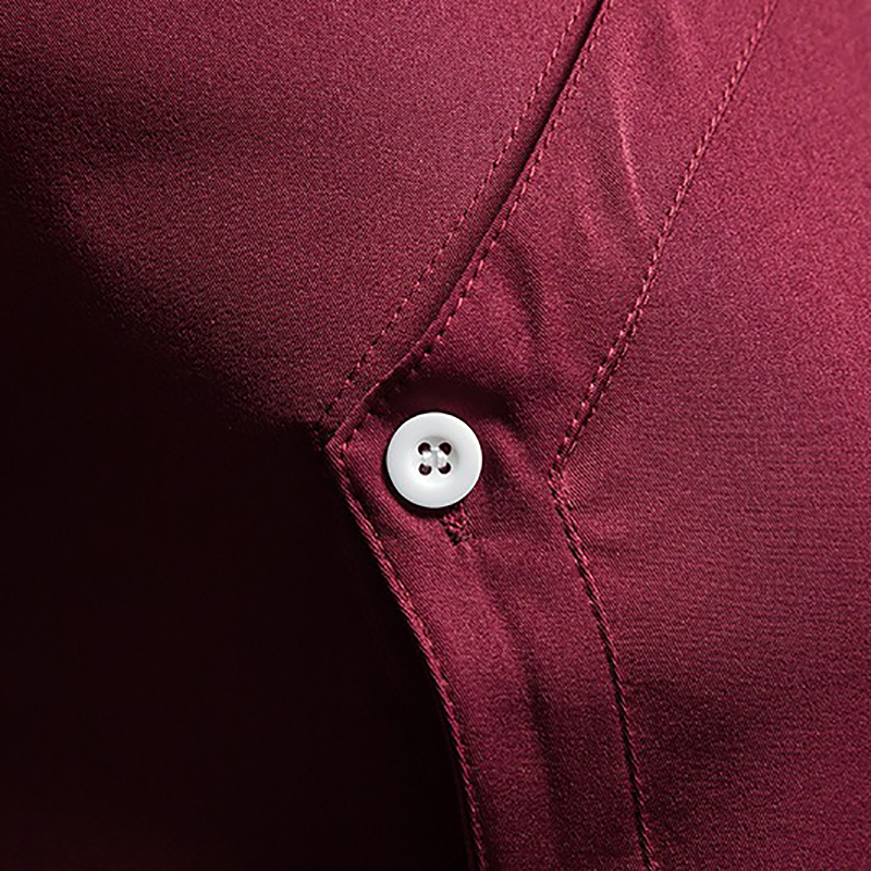 Close-up of the button detail on a burgundy men's asymmetric long-sleeved shirt, showcasing quality craftsmanship.