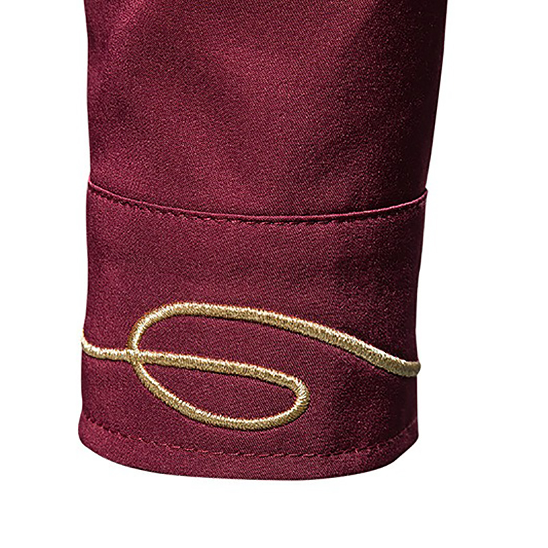 Close-up of the embroidered cuff detail on a men's asymmetric shirt in burgundy fabric.